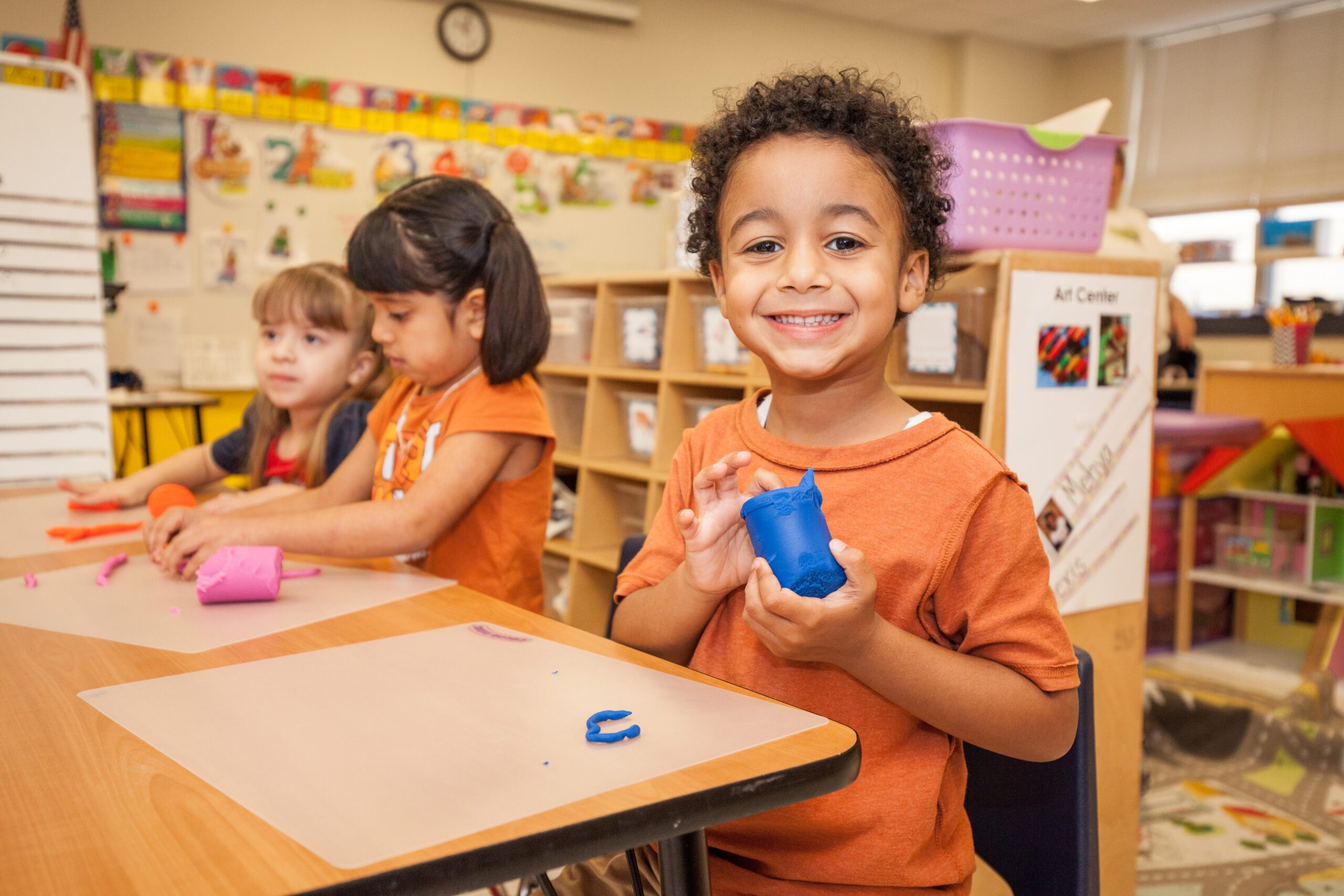 Pre-k student holding play-dough.